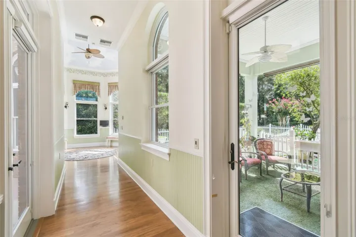 Charming garden room with a vaulted ceiling adorned with a sky mural and expansive panoramic windows that bring the outdoors in.