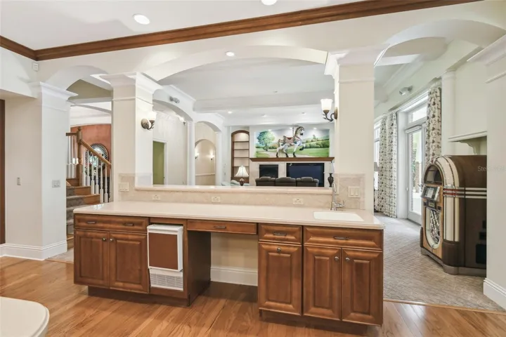 Gourmet chef’s kitchen showcases two expansive islands, three sinks, Corian countertops, custom cabinetry, a Bosch dishwasher, gas cooktop, and a separate ice maker. The adjacent butler’s pantry is perfect for entertaining, featuring a prep area, warming drawer, second refrigerator, and a spacious walk-in pantry.