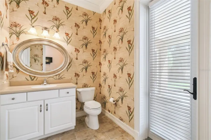 Spacious office with private half bath and direct access to the lanai. Includes a dedicated sewing area with a built-in tabletop and integrated Janome sewing machine, along with additional shelving for ample storage.