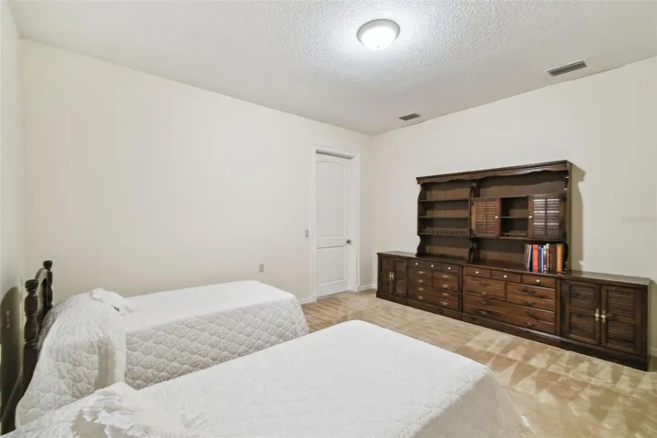 Upstairs features a spacious landing and inviting sitting room. Adjacent to the sitting area is a private guest suite with a connected full bathroom, along with an additional bedroom. The sitting room also includes a convenient kitchenette with a compact countertop, cabinet storage, sink, and mini refrigerator—perfect for guests or relaxing upstairs.