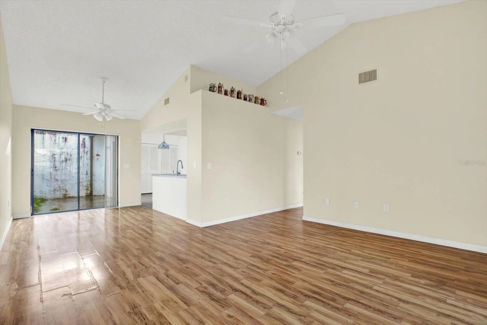 The living room opens directly to the kitchen, with a sliding glass door out to the lanai.