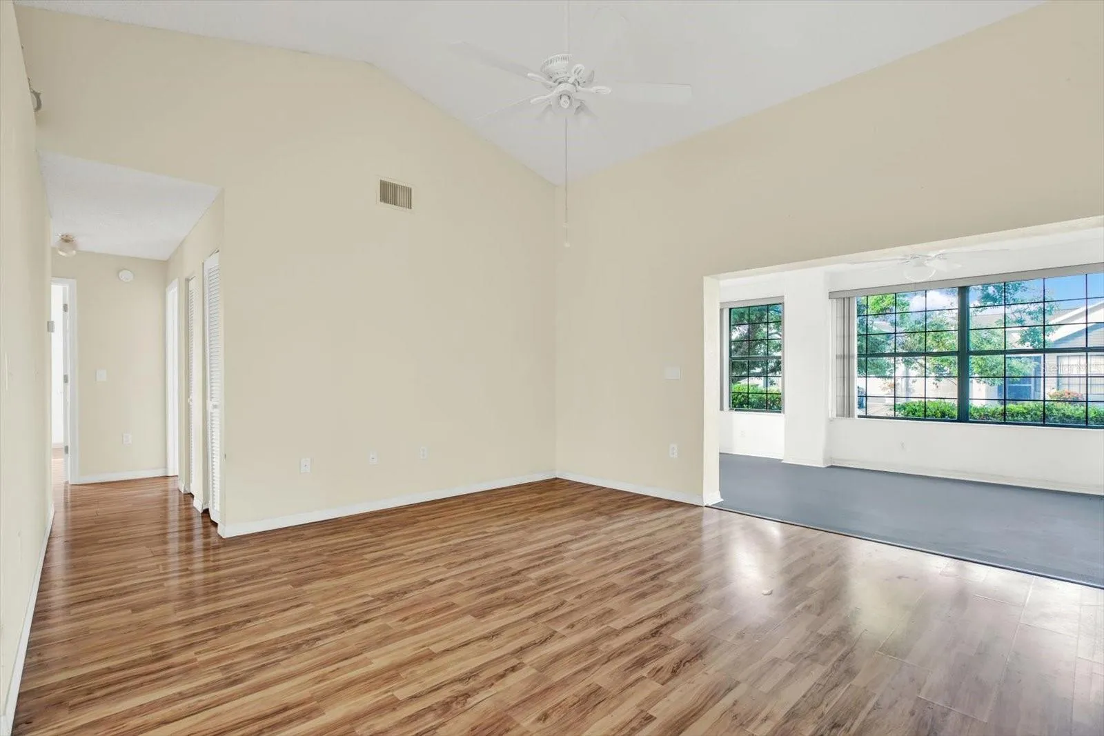 The living room, with vaulted ceilings and a hallway leading back to both bedrooms.