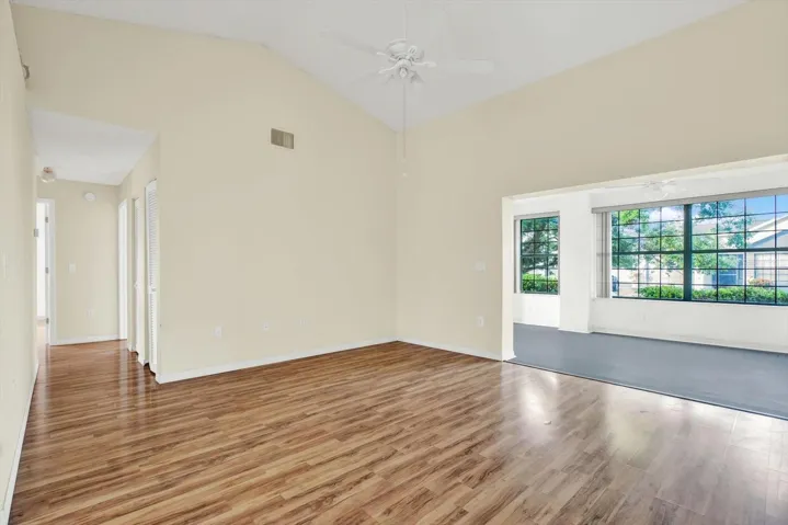 The living room, with vaulted ceilings and a hallway leading back to both bedrooms.