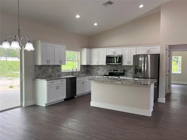 kitchen with granite countertops, stainless steel appliances and backsplash