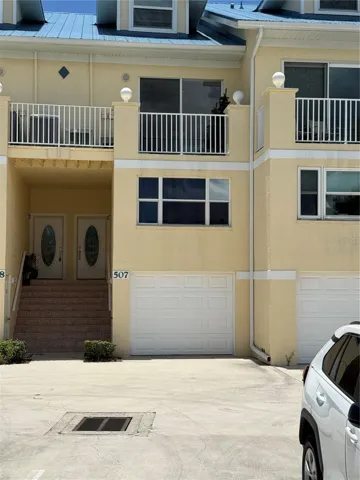 The front of Harbor Village #507, showing the single car garage and steps leading up to the front door.