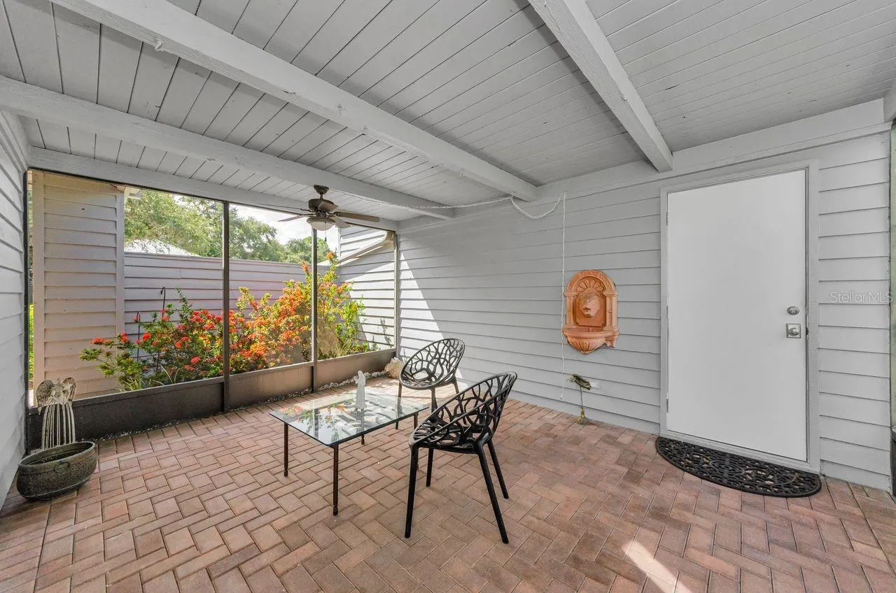 The breezeway next to garage, with brick pavers and the door into the garage.  What a great private space!