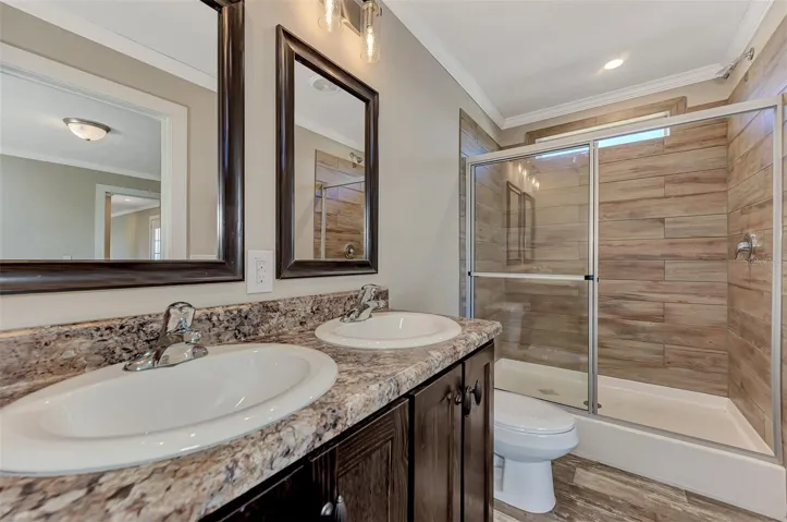 MASTER BATHROOM WITH  SHOWER .  NOTE THE DOUBLE SINKS AND MIRRORS TO THE LEFT.