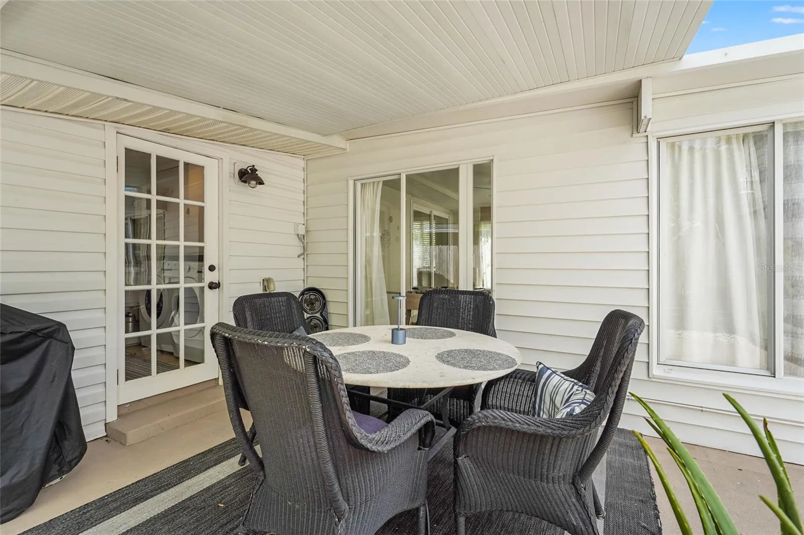 Covered Dining Patio – Dine alfresco under a covered lanai complete with fan, grill station, and cozy all-weather seating—a must-have feature for guests or year-round Florida living.