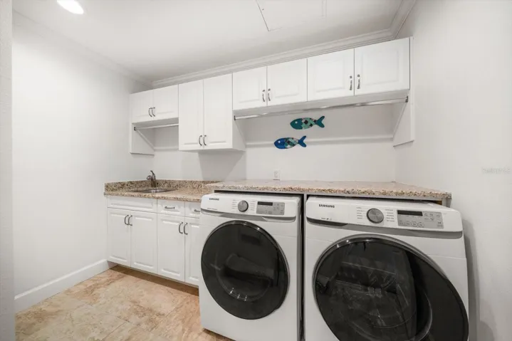 Laundry room with separate utility sink and storage.