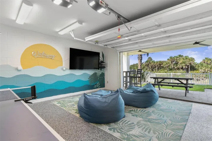 The first-floor game room offers the ultimate hangout spot with a TV lounge, ping pong table, that opens to a covered patio and fenced yard.