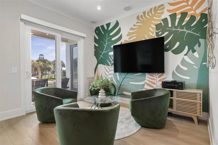 This vibrant second-floor den offers the perfect space to relax or entertain, with sliding glass doors opening to a breezy balcony.