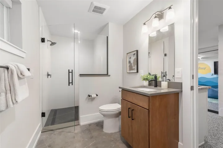 Conveniently located off the game room, this full bath is perfect for easy clean-up after a day at the beach or on the boat—featuring a walk-in shower and modern finishes.