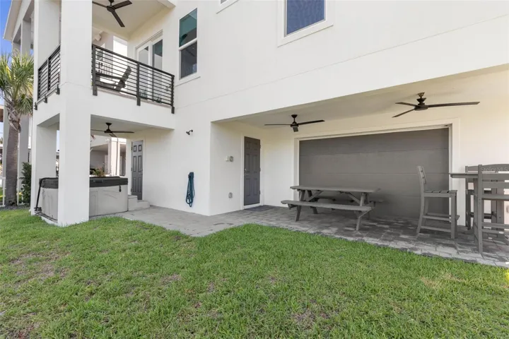 Designed for beachside relaxation, this covered lower-level retreat offers a hot tub, alfresco dining.