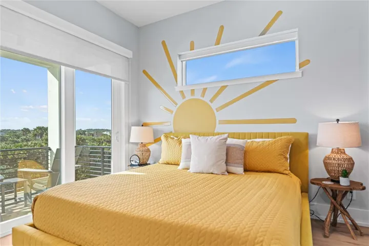 This vibrant bedroom brings the sunshine in—complete with scenic views and balcony.