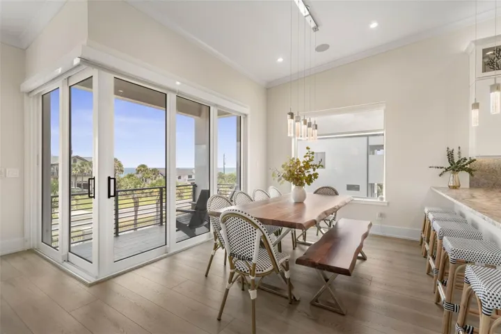 This elegant dining space opens to a private balcony with breathtaking sunrise views—perfect for morning coffee—and flows seamlessly into the expansive breakfast bar and kitchen for effortless coastal entertaining.