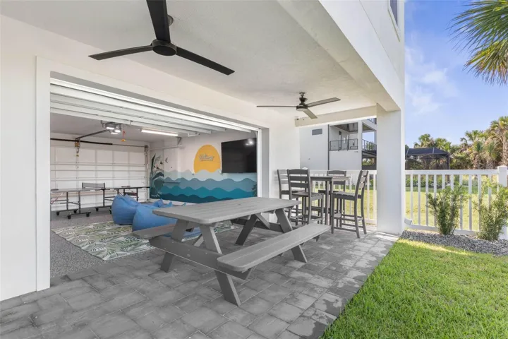Just off the game room, step into your shaded outdoor lounge—complete with a picnic table, high-top seating, and dual ceiling fans for those warm Florida afternoons. The perfect spot for grilling, chilling, or just soaking in the salty breeze.