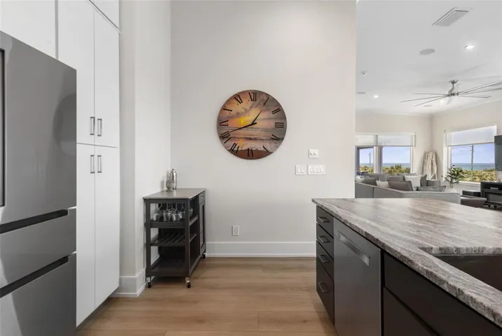 Abundant custom cabinetry offers elegant storage solutions with a sleek, modern design—perfect for keeping your coastal kitchen organized and clutter-free.
