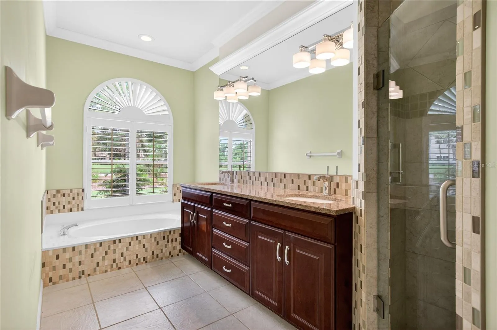 Primary ensuite bath with garden tub, separate shower, double sinks, granite counters