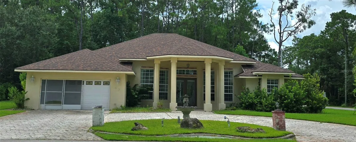 front of home with fountain and horseshoe stamped concrete driveway