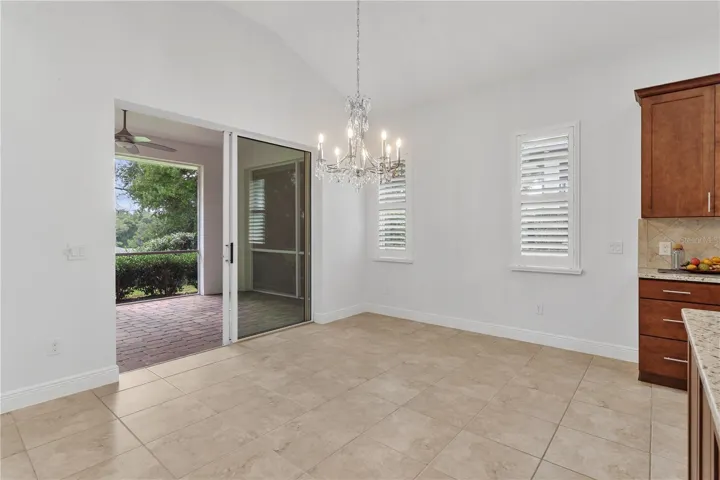 Dining area showcases a sparkling crystal chandelier and direct access to the lanai