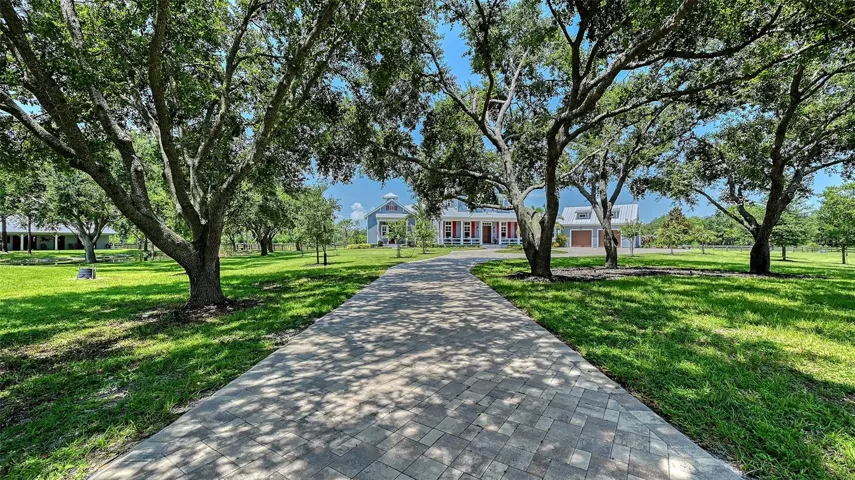 Driveway & Walkways: A 12’ wide paver driveway in a Patriot-style straight T pattern (Red/Tan/Charcoal)connects to a circular parking area and 4’ wide walkways to the front and master entry porches.Smooth-finish concrete graces the entry porch, lanai, and garage, with a full flake epoxy finish inthe garage