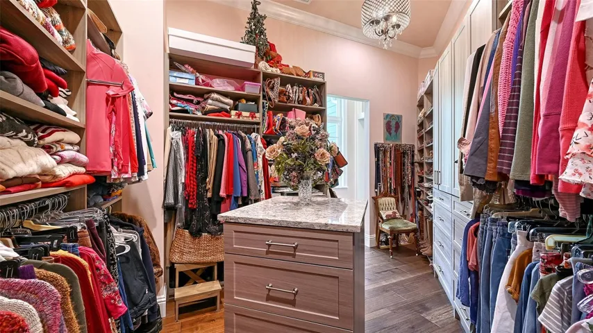 The custom closet for Primary Bedroom #2 is a showstopper, measuring an impressive 15' x 14'! This luxurious space features custom hard shelving that maximizes storage and organization, while a stunning center island topped with elegant granite adds a touch of sophistication. It's not just a closet; it's a dream dressing room that elevates your everyday routine!