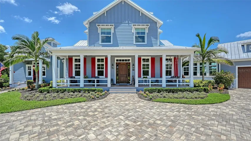 The Front and Priimary entry feature elegant Cheyenne 2-panel plank doorswith sidelights and transoms, painted for a refined finish.