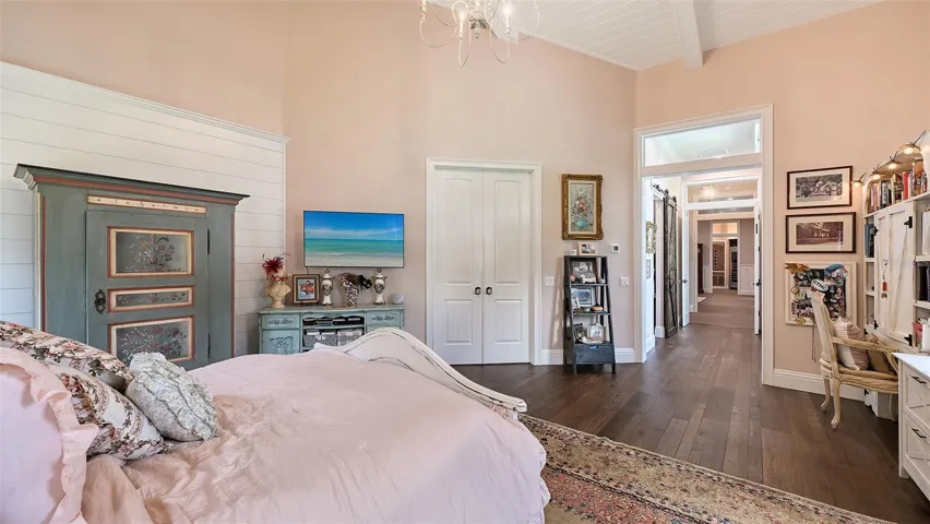 A long, private hallway gracefully leads to Primary Bedroom #2, featuring elegant double doors that create a sense of anticipation and exclusivity. This inviting entrance not only enhances the room's privacy but also adds a touch of sophistication, making the transition into this luxurious retreat feel truly special.