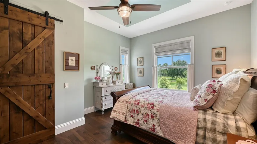 Ascend to the upper level, where you’ll discover two charming en-suite bedrooms that exude warmth and character. One of these delightful retreats measures 13' x 15' and boasts a spacious walk-in closet, measuring an impressive 10' x 12'. This closet is beautifully highlighted by custom barn doors crafted from Glass Craft Knotty Alder, complete with sleek black hardware that adds a touch of rustic elegance.