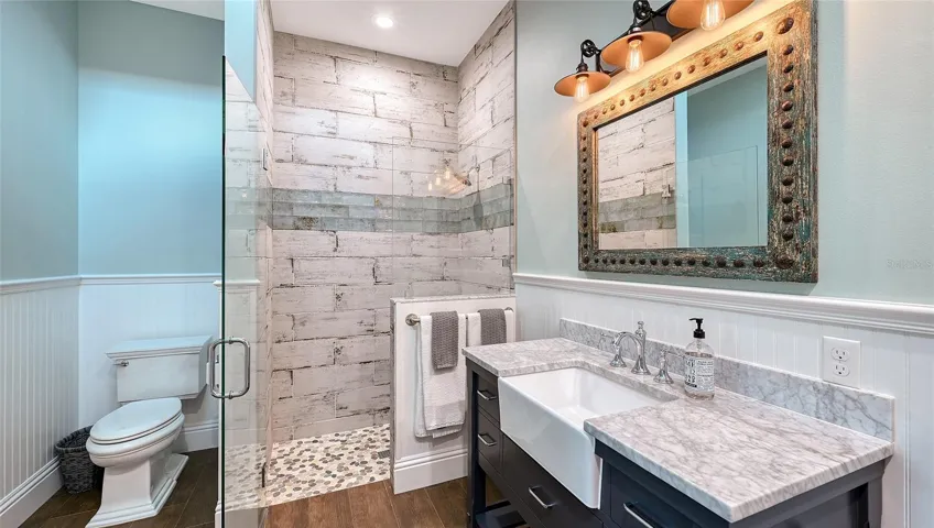 The upstairs en-suite guest bathroom #3, measuring 13' x 8', is a stunning retreat that combines elegance and functionality. Adorned with Mir Retro Blanco 8" x 24" wall tiles arranged in a stylish brick pattern, the walls create a fresh and modern aesthetic, beautifully complemented by three rows of Iberian Valencia Ash 4" x 16" borders that add a touch of sophistication. The luxurious shower features a Shaved Dapple Cloud 12" x 12" floor, laid in a straight set, providing a chic and contemporary feel. Underfoot, the Haven Barrel 8" x 40" floor tile ties the entire look together, creating a cohesive and inviting atmosphere. This bathroom is not just a functional space; it’s a luxurious sanctuary designed for relaxation and rejuvenation!