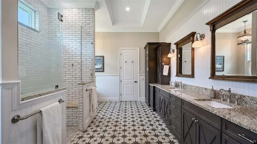 The Primary Bathroom is further enhanced by Marsh Full Overlay Level 8 & 10 maple cabinets, showcasing solid wood door frames and elegant veneer center panels. With dovetail drawers and soft-close undermount guides, these cabinets combine functionality with exquisite craftsmanship, providing ample storage while adding a touch of sophistication to this luxurious space.