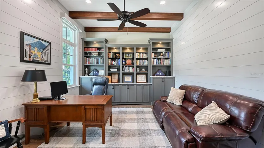 The Study, measuring 16' x 13', features beautifully painted poplar beams and drywall ceilings, complemented by stunning handcrafted built-ins and cabinets that provide the ultimate in organization and style.