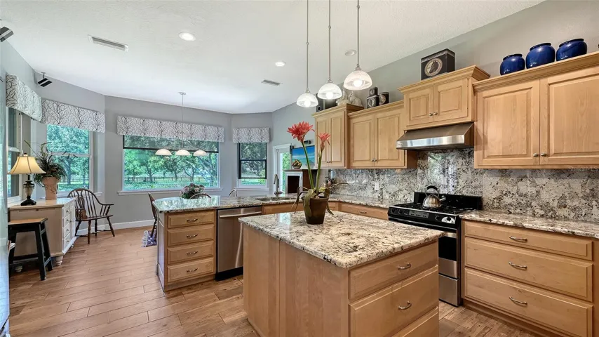 KITCHEN AND BREAKFAST NOOK: This kitchen is a chef's dream, featuring top-of-the-line solid wood hand-crafted Dutch built cabinets, including the boxes—no expense was spared in this exquisite design. The cabinets boast dovetail joint construction and slow-closing mechanisms, making them not only stunning but also highly functional.Gorgeous granite countertops and a matching backsplash add elegance, while a HUGE built-in center island with three stylish pendant lights completes the picture perfectly. The Thermador oven is a chef's delight, offering "dual fuel" functionality with an electric oven and a gas cooktop for versatile cooking options. And of course, there’s a spacious pantry to keep all your culinary essentials organized. This kitchen is truly a masterpiece, designed for both beauty and practicality!