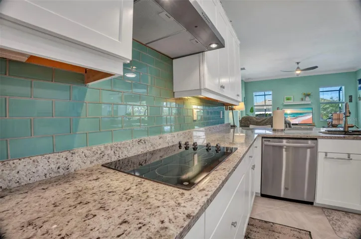 Under cabinet lighting and cooktop and tile accent backsplash.