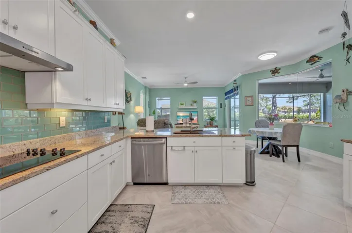 Bright kitchen with built-in cooktop, breakfast nook and family room beyond.
