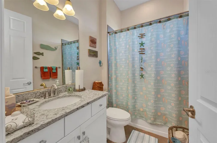 Guest bathroom number 2 with granite counters and single vanity. Includes full bath and shower.