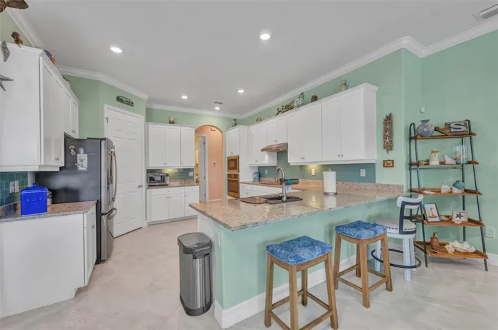 Large kitchen with white shaker cabinets and breakfast bar.
