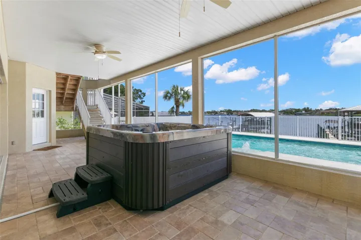 First floor screened lanai with hot tub, door leading to downstairs bedroom