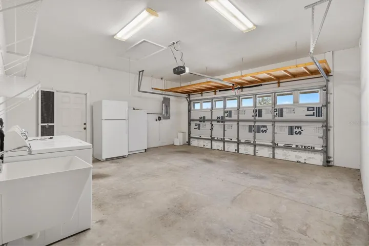 Refrigerator and standup freezer in garage, utility sink, utility door leading to side yard.  Overhead storage above garage door.