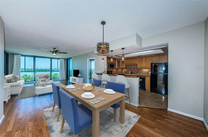 Virtually staged dining room open to living room and kitchen