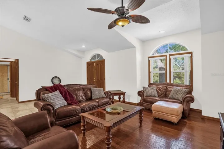 Spacious open concept living room with hardwood floors and vaulted ceilings
