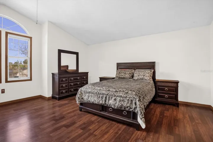 Primary suite with vaulted ceilings and hardwood floors