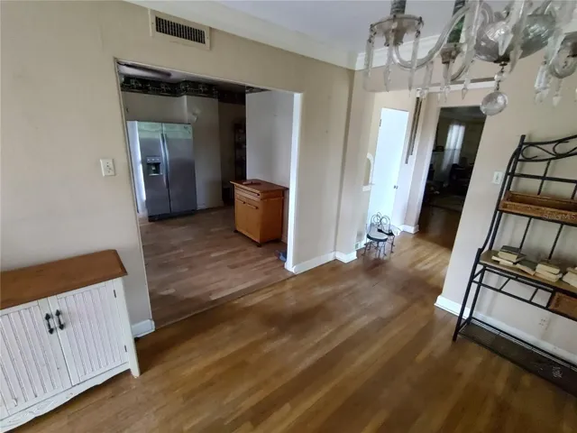Dining room with view of Kitchen to the left, front door to the right.