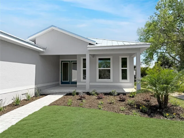 Front Exterior Entry featuring Front Porch, Landscaping & Metal Roof