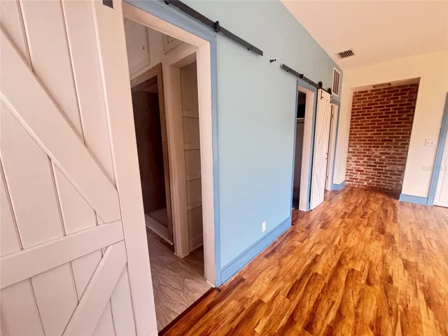 The primary ensuite offers a spacious layout with beautiful wood flooring, abundant natural light, and charming architectural elements