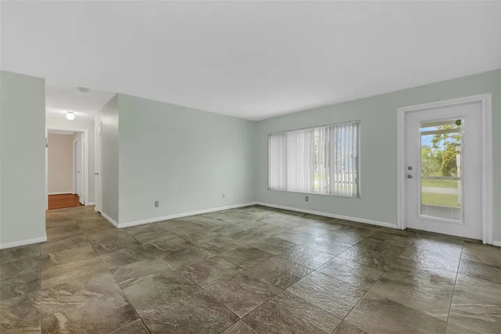 Light filled living room with impact door with in door privacy screening.