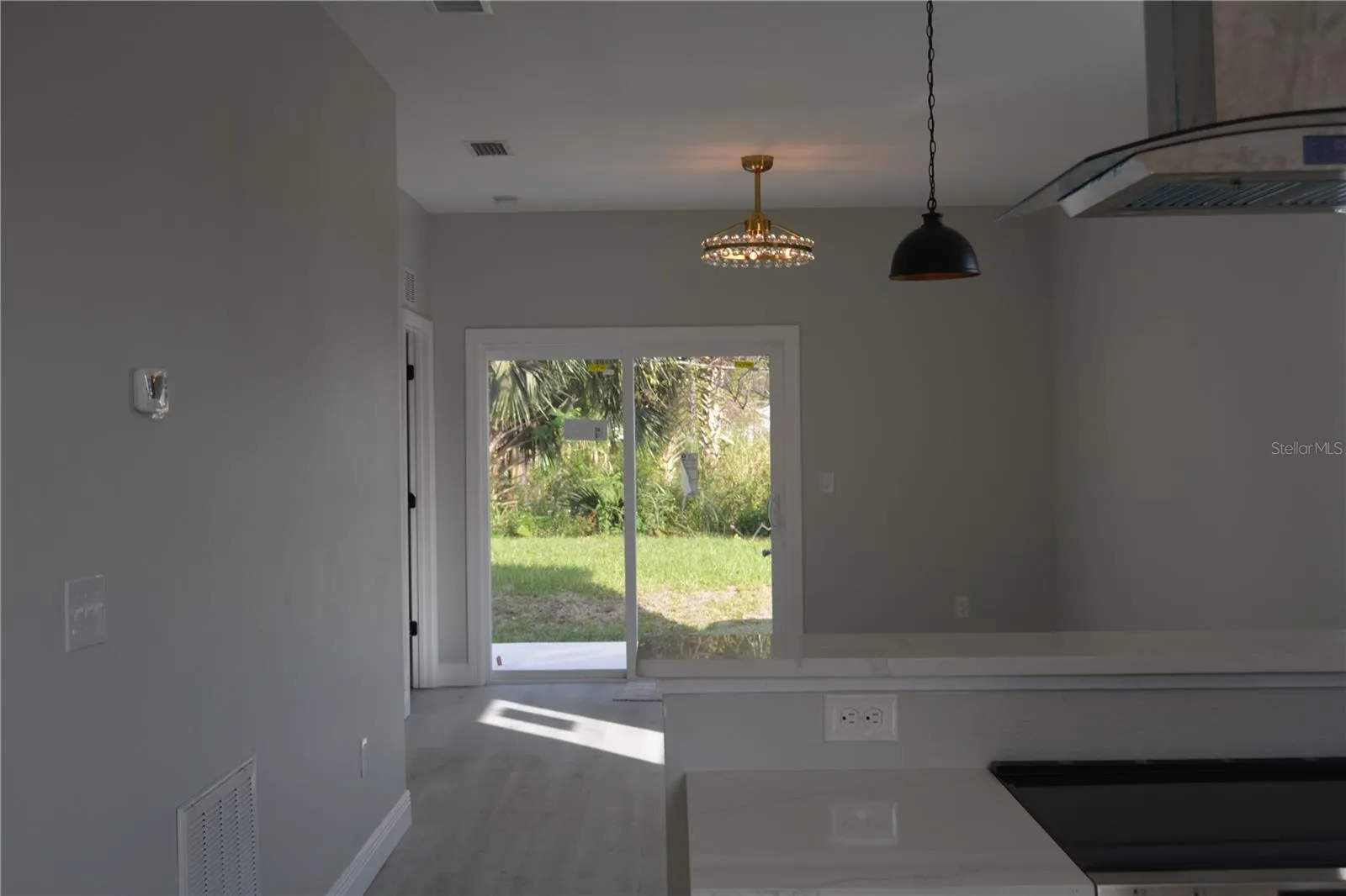 view from the kitchen looking towards the back double slider doors