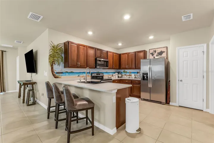 Kitchen with stainless appliances, tile throughout and large pantry