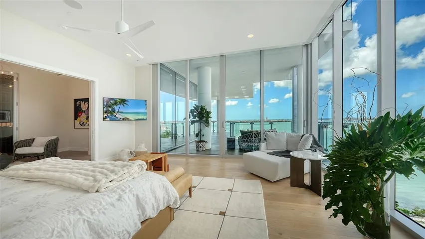 Wake up to your elevated paradise in this luxurious Primary bedroom, where floor-to-ceiling glass walls frame breathtaking water and city views. Thoughtfully designed for comfort and style, the space features Lutron™ room-darkening shades for ultimate privacy and relaxation
