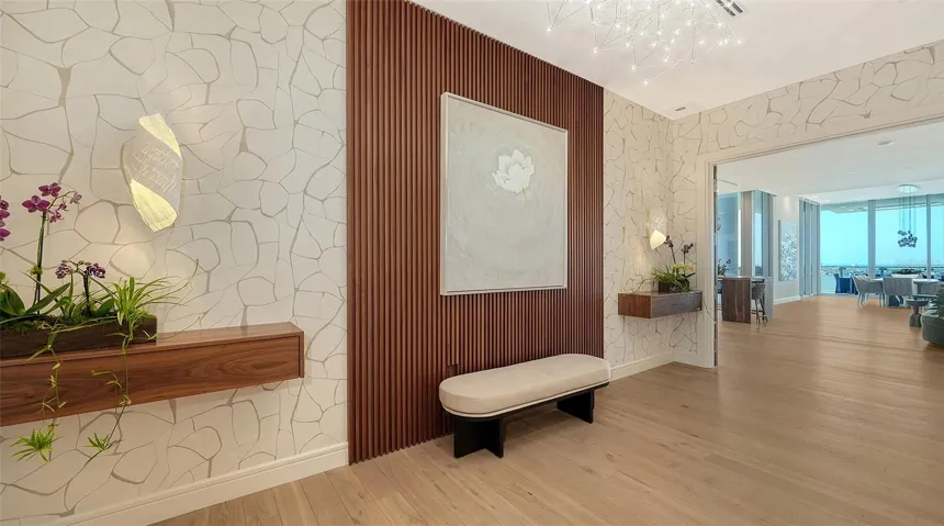 Walnut feature wall, luxury lighting and Schumacher™ wallpaper welcome you into your privcate lobby